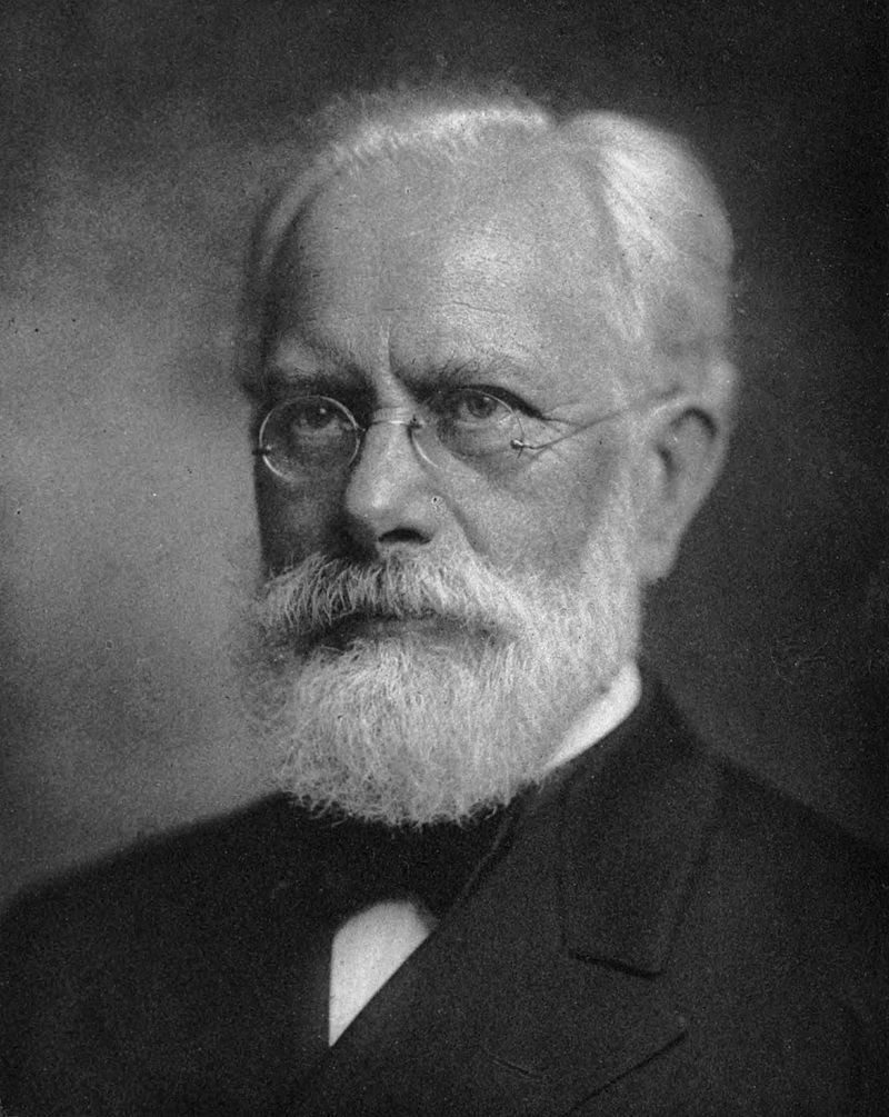 black and white photo of older man with beard and glasses