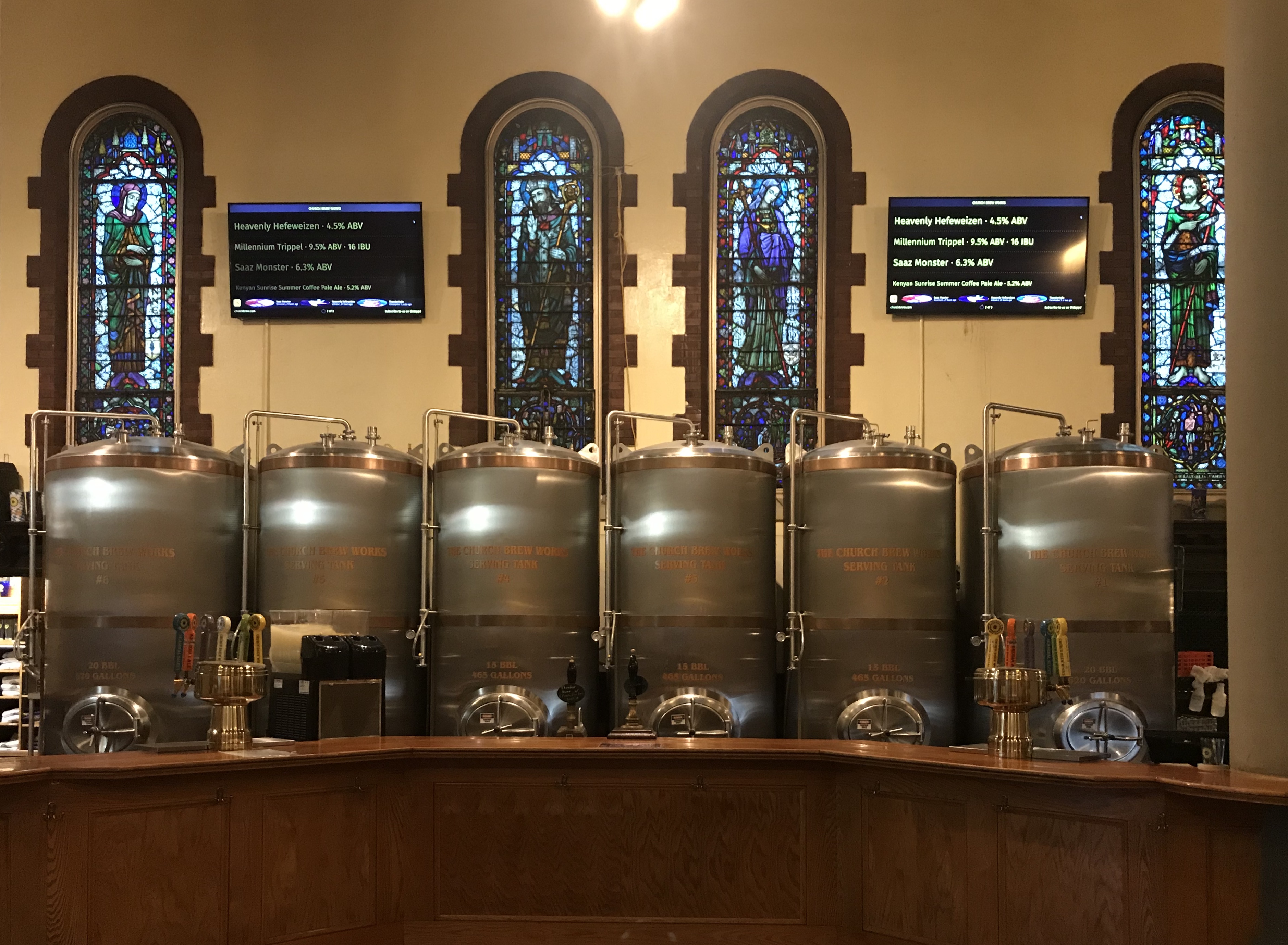beer brewing set up in the pews in front of stained glass windows depicting mary and jesus